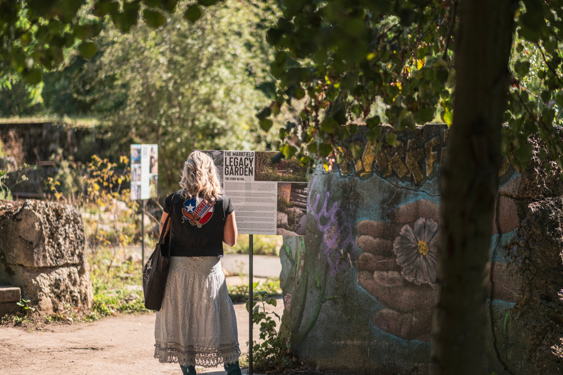 Visitor reading the Markfield Legacy Garden board