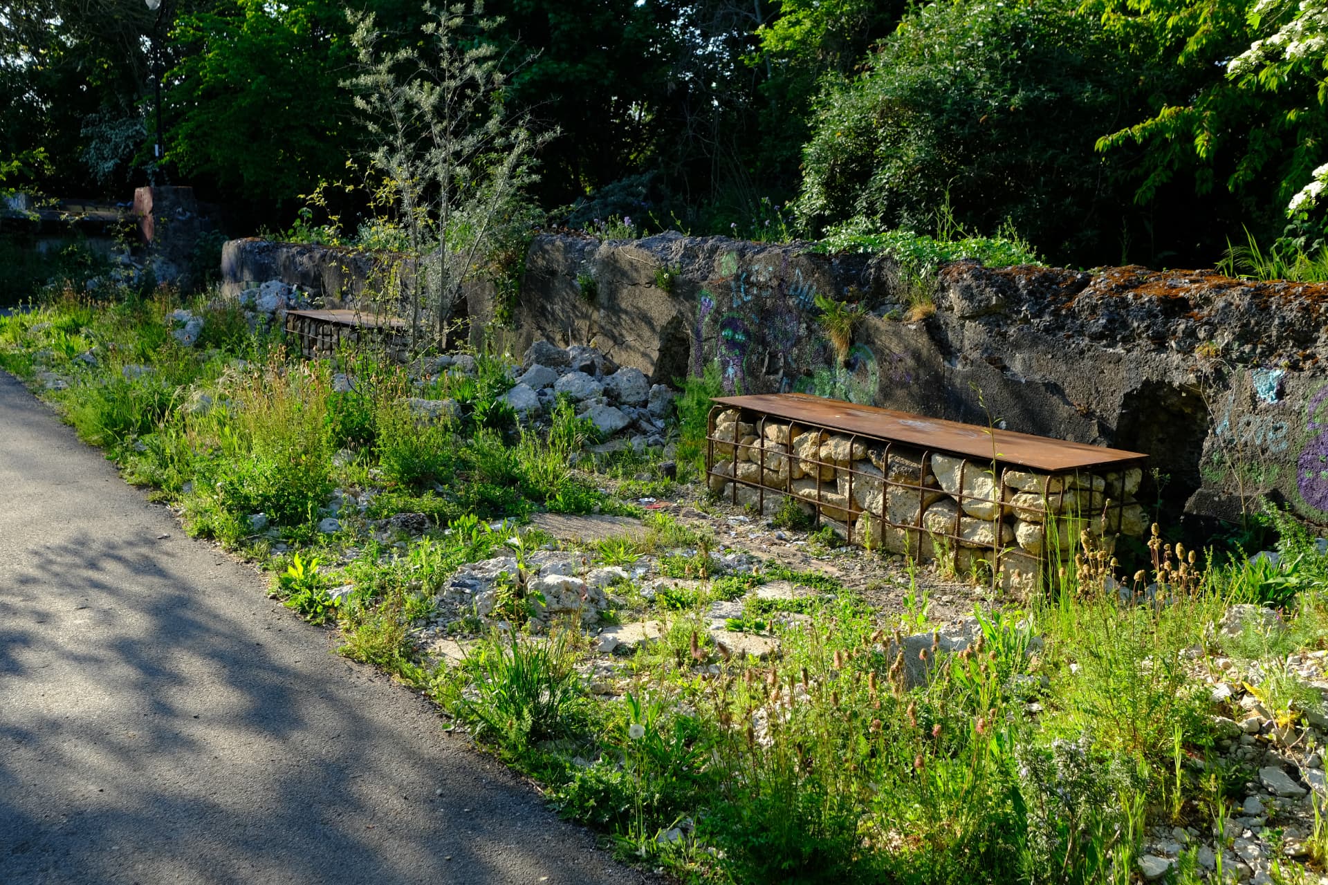 Gabion benches with corten steel tops set into the old filtration bed walls